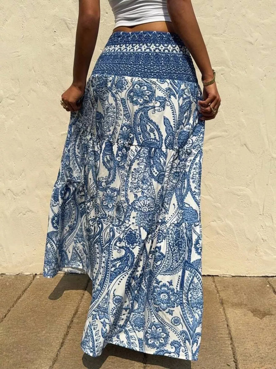Maxi skirt with blue and white paisley print, tiered design, and smocked waistband.