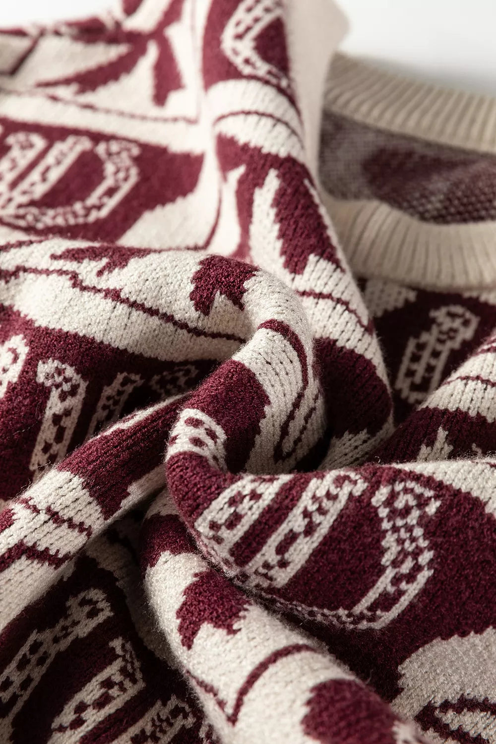 pullover sweater featuring bow and horseshoe motif in burgundy with 52% viscose, 26% polyester, 22% polyamide Care