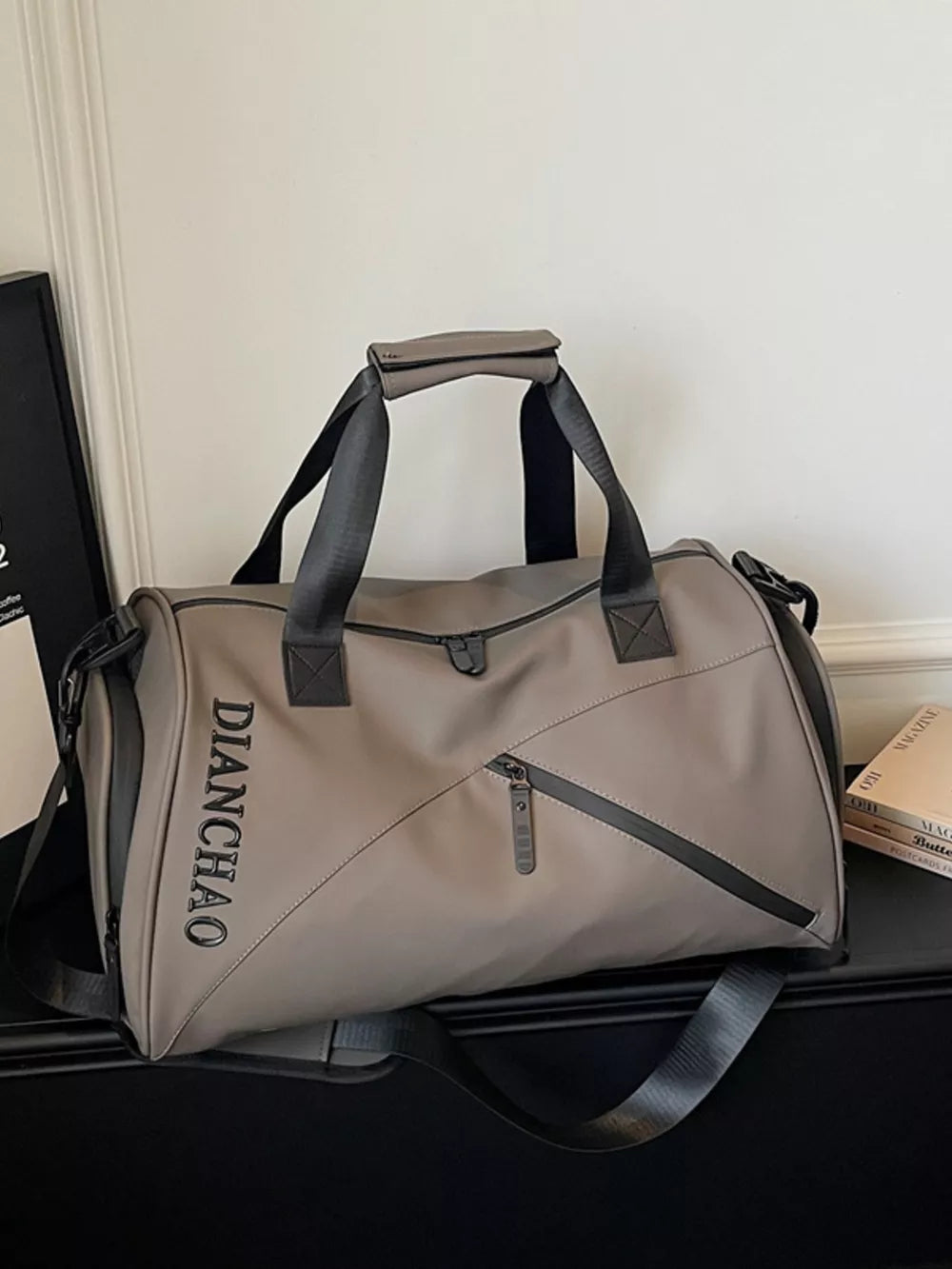 Spacious grey Oxford travel bag with padded strap and zippered pockets.