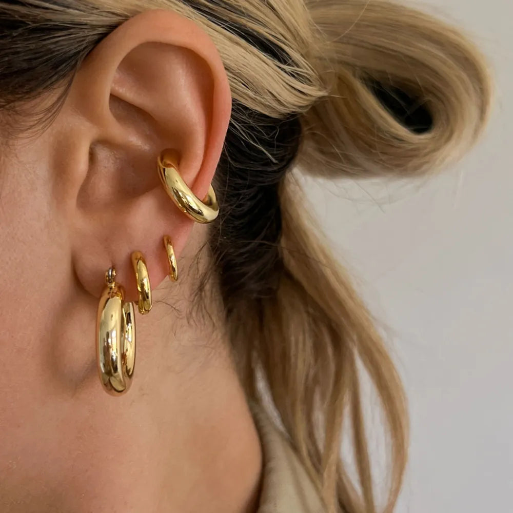Gold-tone sculptural ear cuff duo and hoop earrings set.