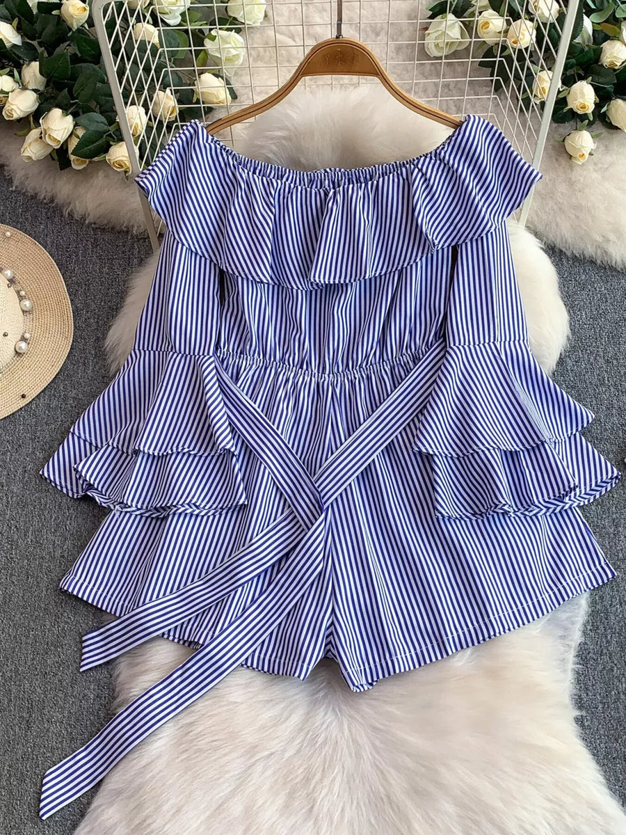 Blue striped off-shoulder romper with ruffles and a belted bow detail.