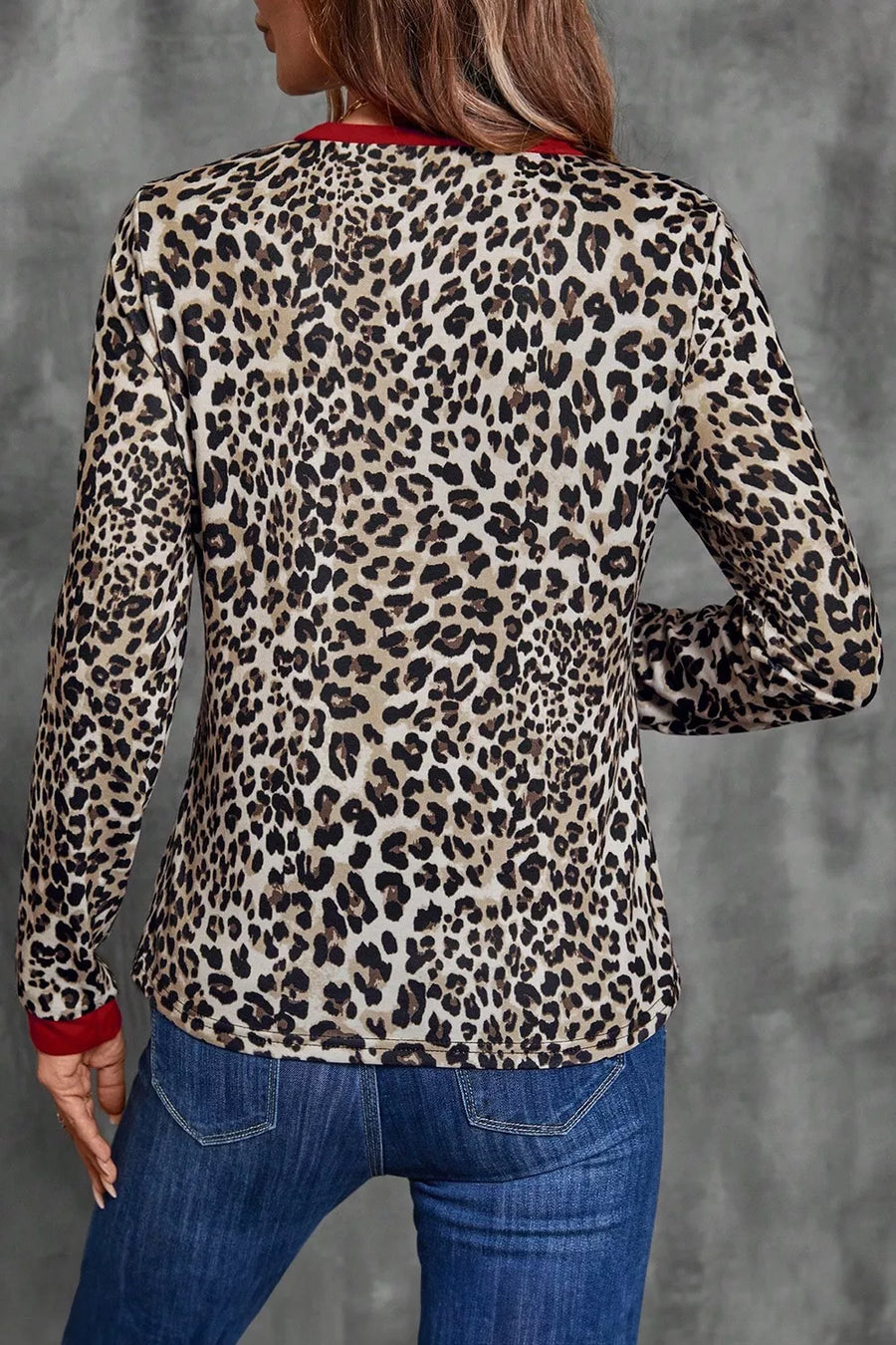 Leopard print long-sleeve blouse with red trim at the neckline and cuffs.