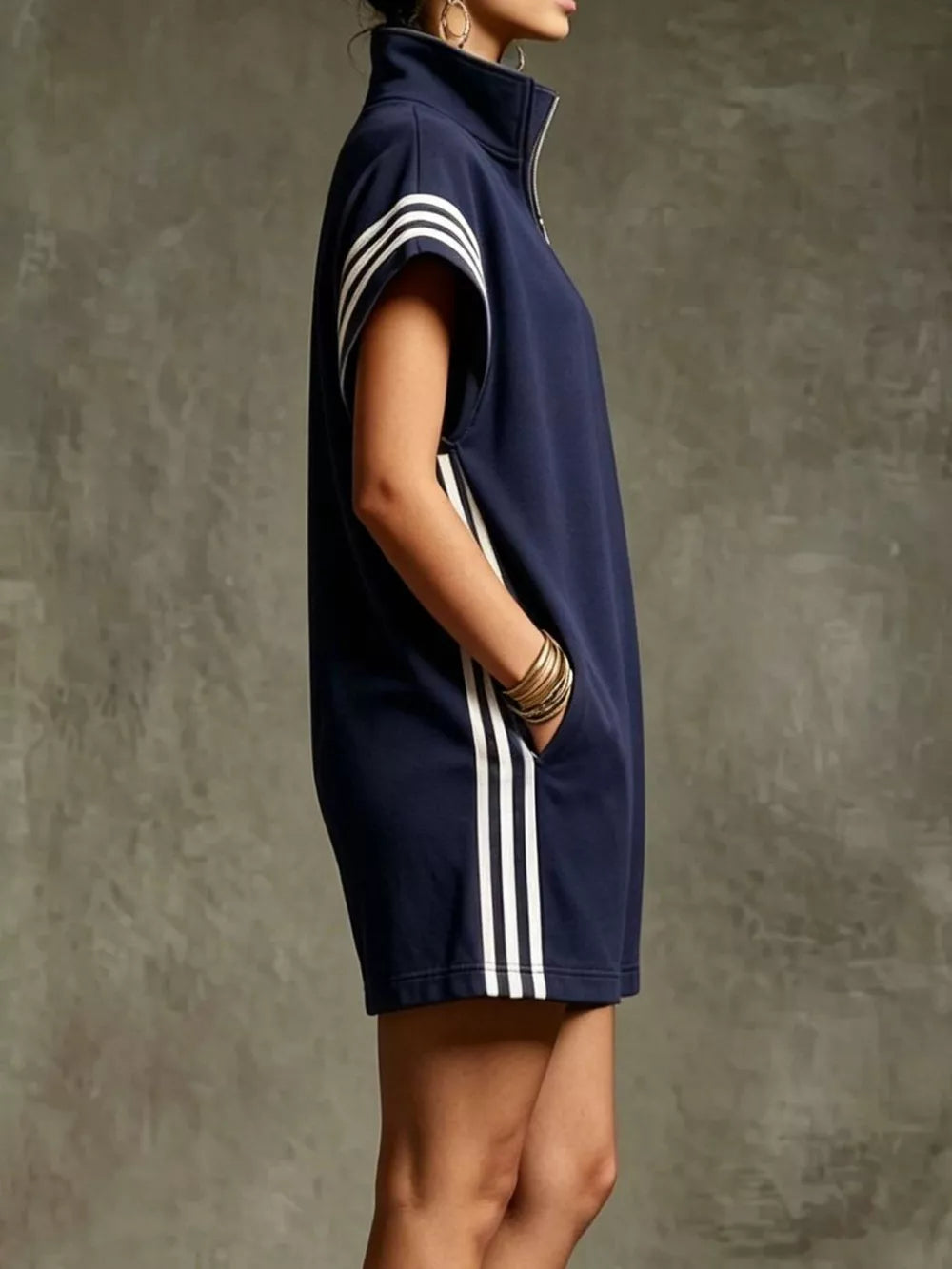 Navy blue sporty zip-up romper with white stripes on sleeves and sides, and pockets.