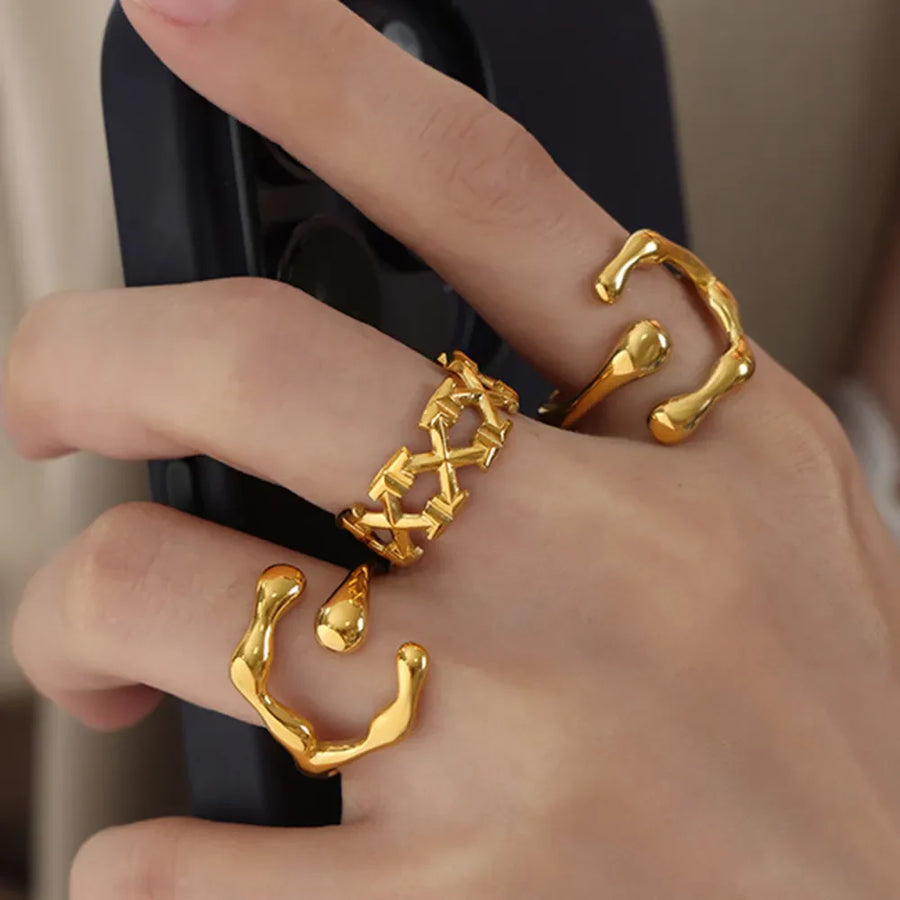 Geometric lattice gold ring with abstract gold rings on fingers.