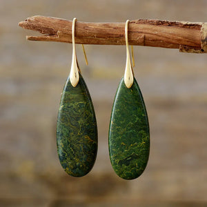 Gold teardrop dangle earrings with green stone grain detail