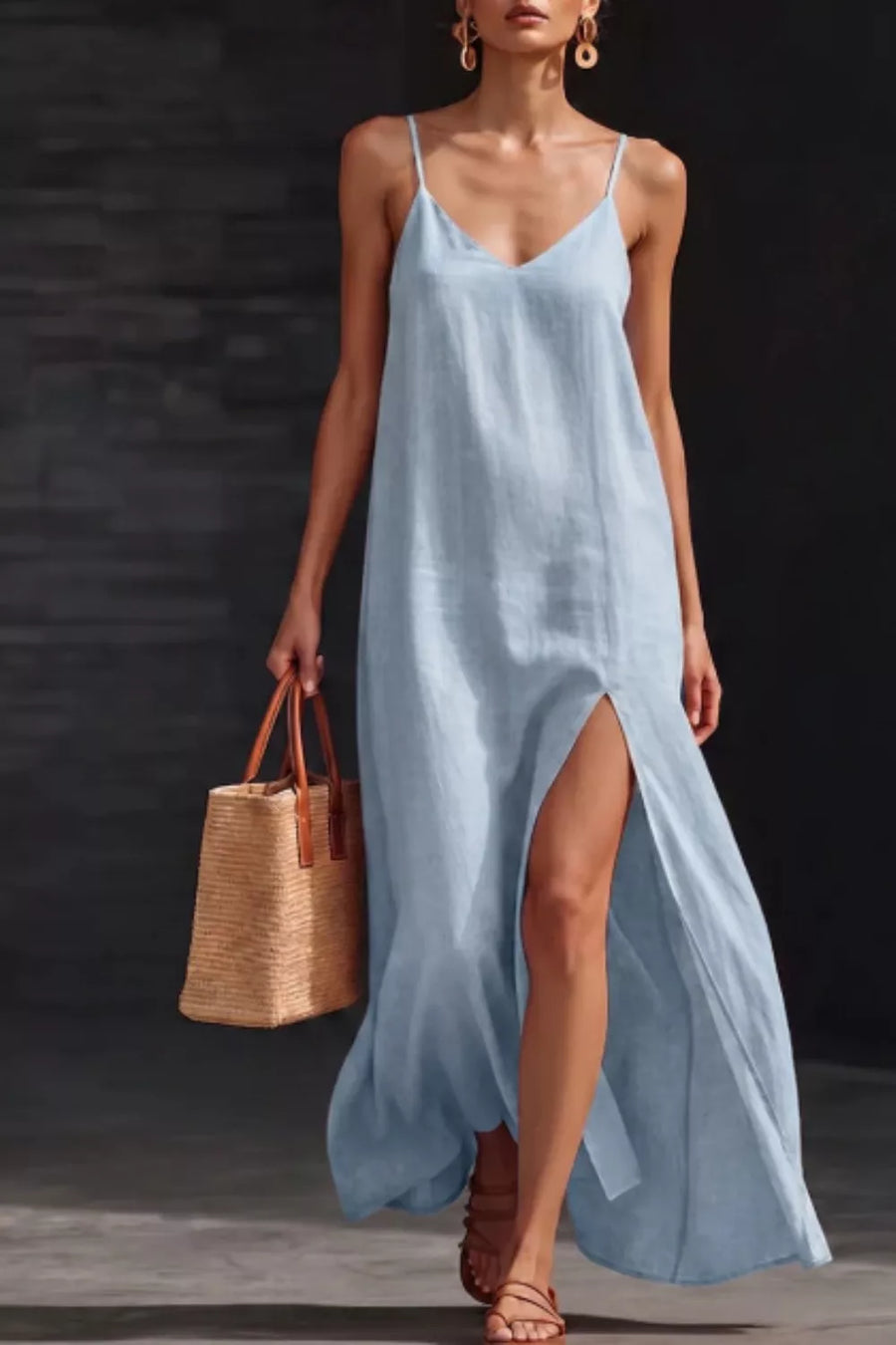 Light blue V-neck maxi dress with spaghetti straps and a high slit, styled with a straw tote bag.