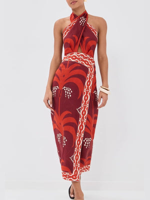 Tropical print halter neck dress with cutout detail and wrap skirt.