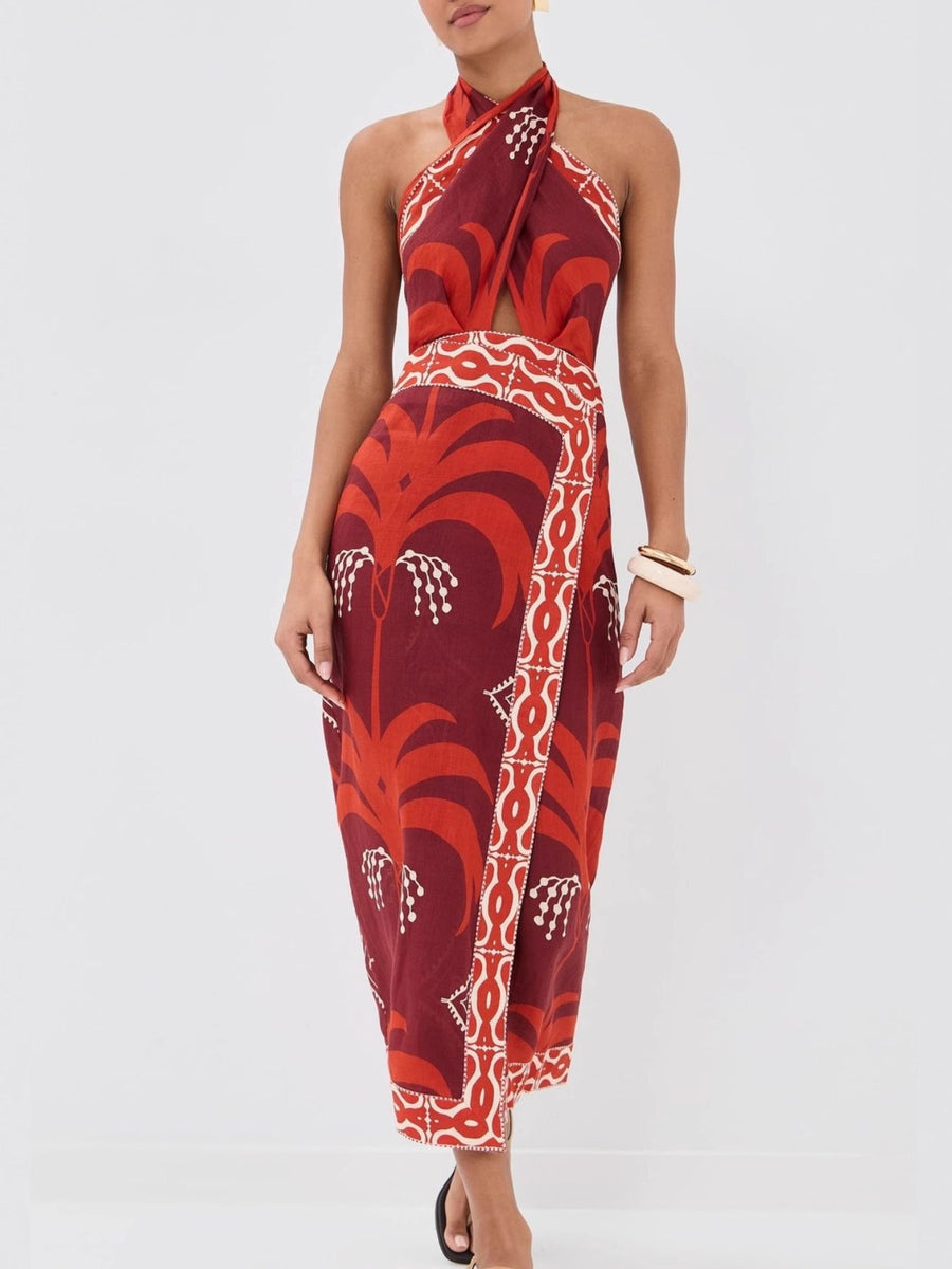 Tropical print halter neck dress with cutout detail and wrap skirt.