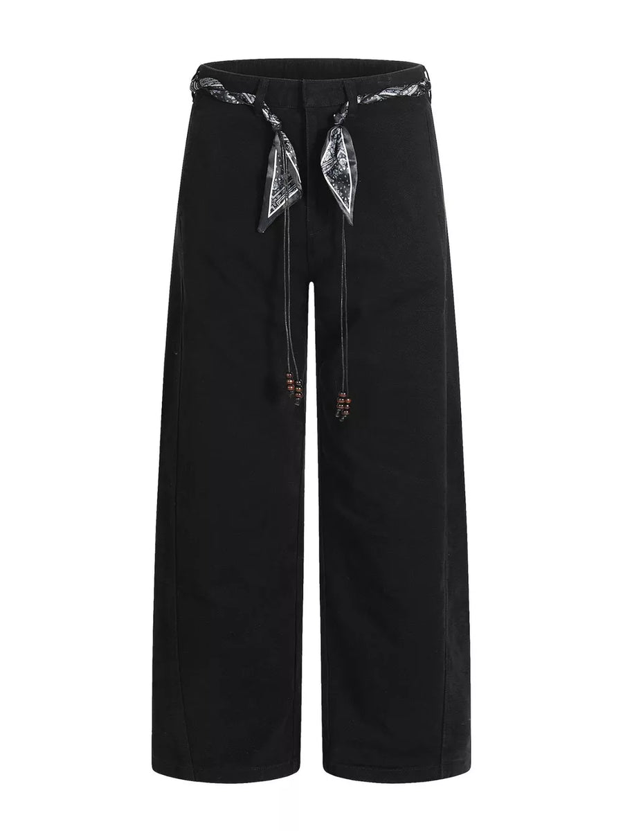 Black maternity pants with wide legs and a patterned belt with beaded ties.