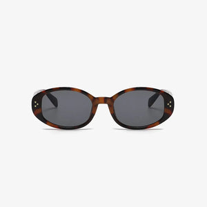 Tortoiseshell oval sunglasses with star embellishments and dark lenses