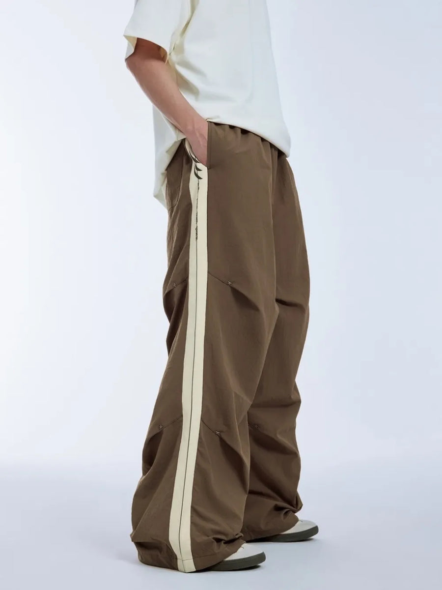 Brown relaxed fit sweatpants with cream side stripe and drawstring waist.