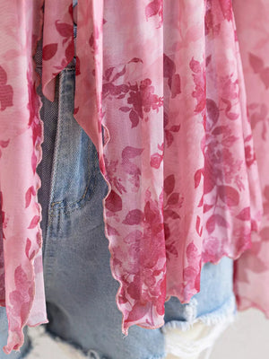 Pink floral chiffon blouse with ruffled hem detail.