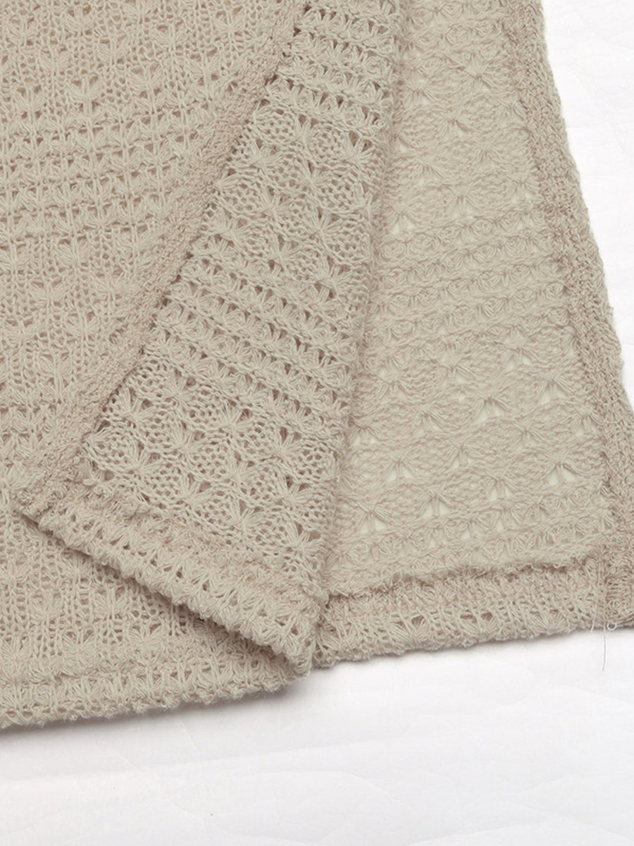 Beige knit maxi dress with cutout details and a slit, featuring a textured open-weave pattern.