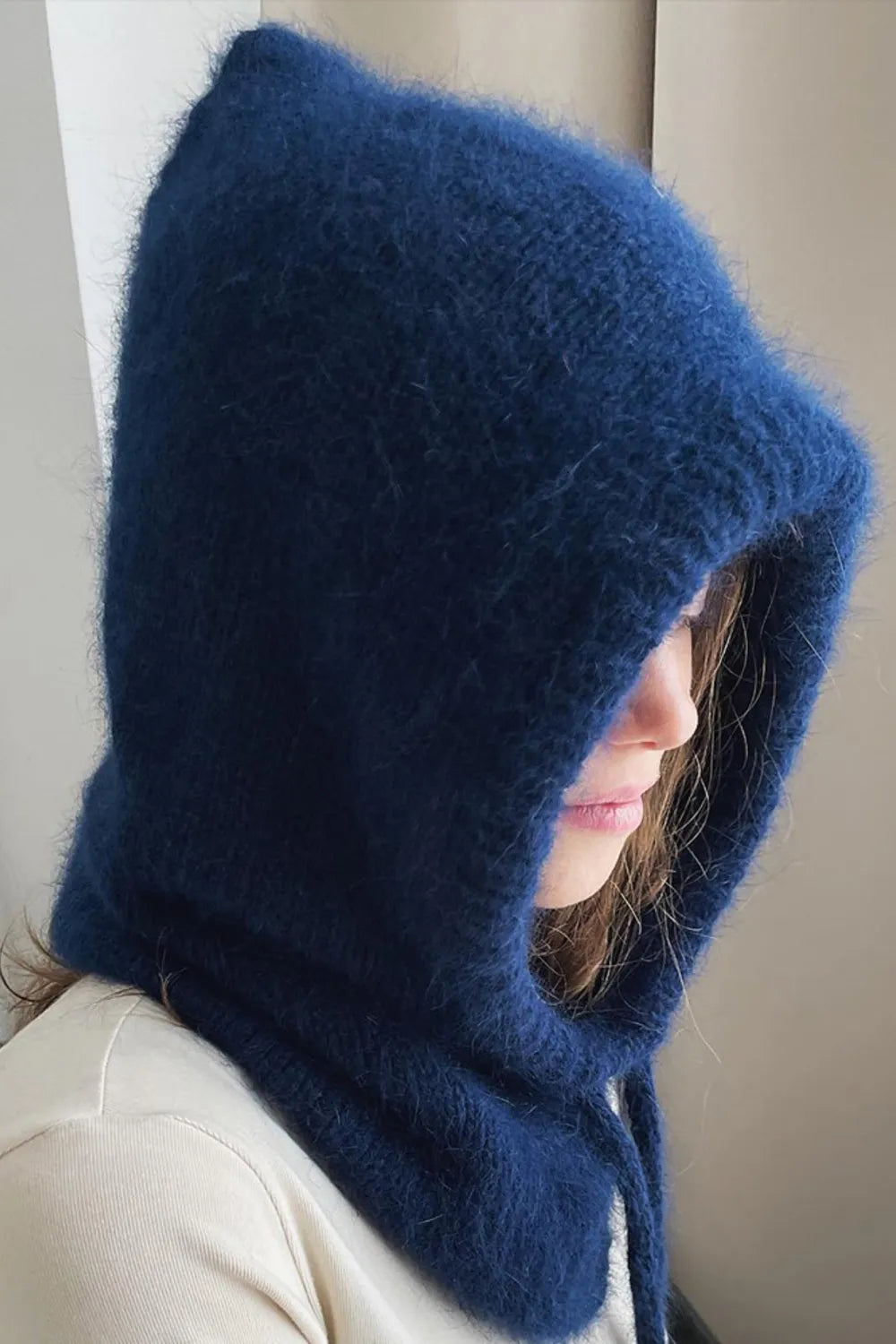 Dark blue hooded knit balaclava with fuzzy texture and drawstring detail.