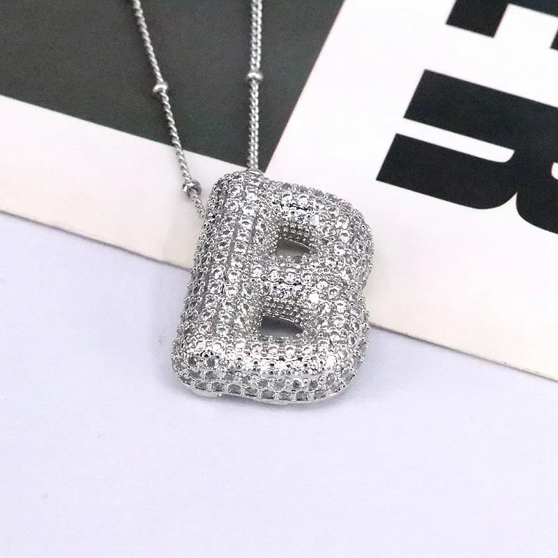 Pave initial bubble pendant necklace with letter B in silver tone.