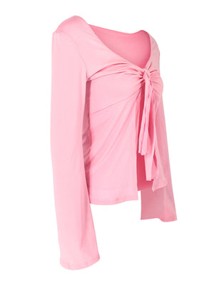 Pink tie-front long sleeve blouse with a V-neckline and draped front detail.