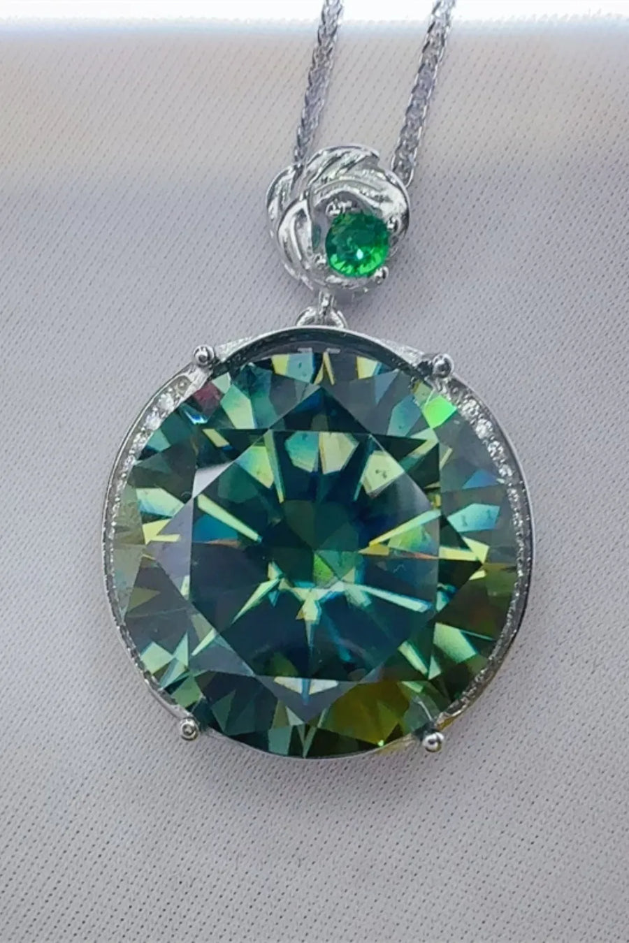 Dark green moissanite and sterling silver pendant necklace with diamond accents.