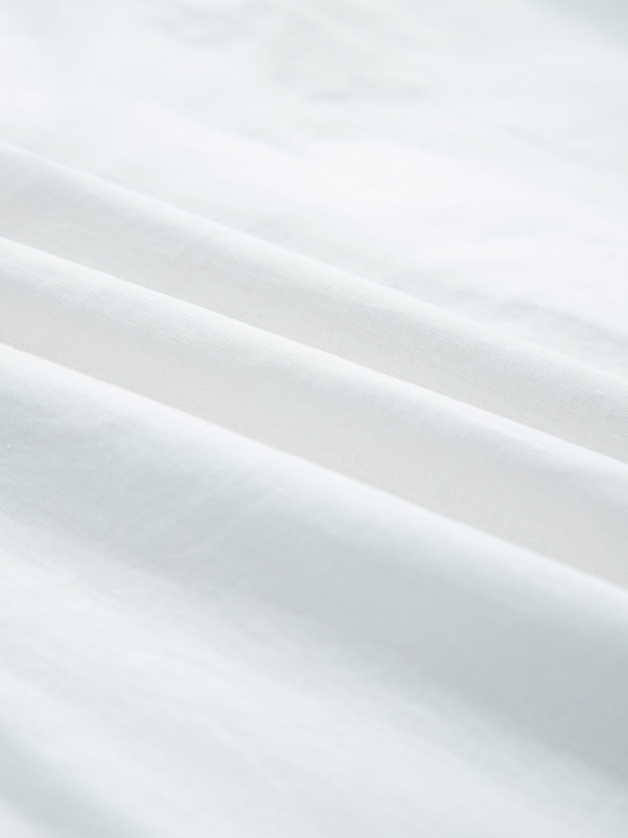 White cotton eyelet embroidered sheer shirt with button-down detail.