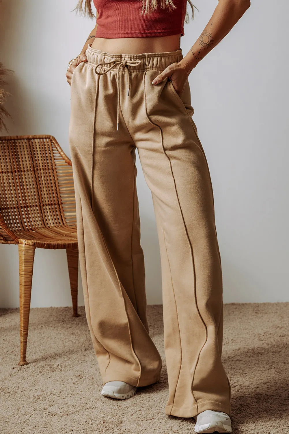 Tan wide-leg sweatpants with seam detail and drawstring waist.