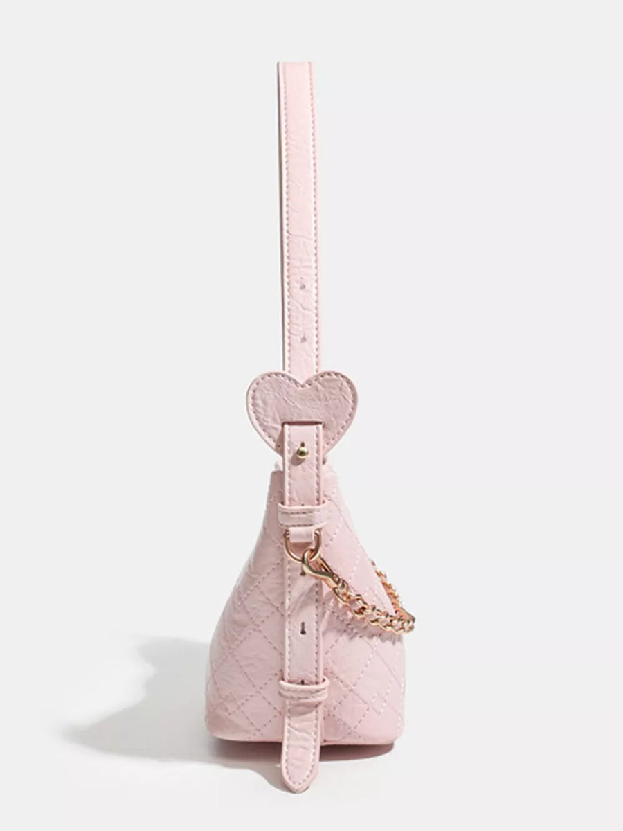 Pink quilted bucket bag with heart strap detail and gold chain accent
