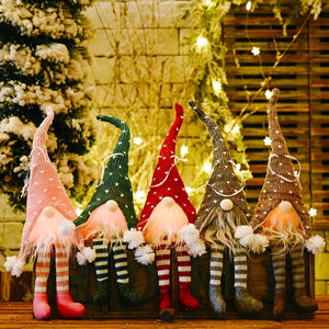 Knitted gnome ornaments in blush pink, dark green, deep red, khaki, and light gray with heart patterns and striped legs.