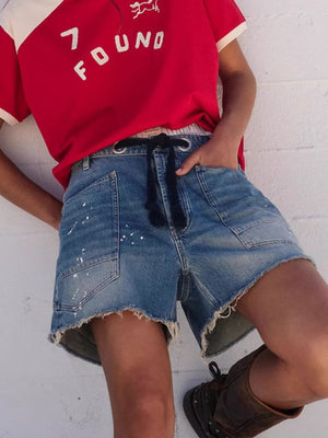 denim shorts in blue featuring raw hem and relaxed fit