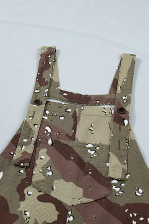 Cropped denim overalls with camouflage pattern and button details.