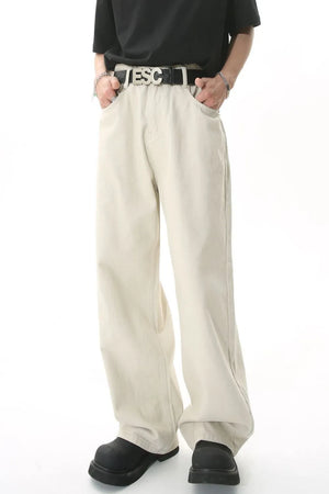 Wide-leg beige denim jeans with a relaxed fit, shown on a model with hands in pockets.