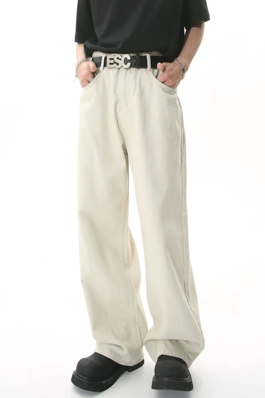 Wide-leg beige denim jeans with a relaxed fit, shown on a model with hands in pockets.