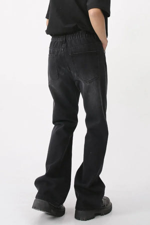 Dark wash denim wide-leg trousers with vertical seams and an elastic waistband.