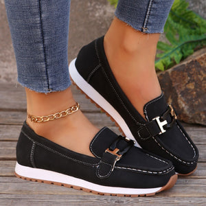 Black casual slip-on loafers with buckle detail and contrast stitching.