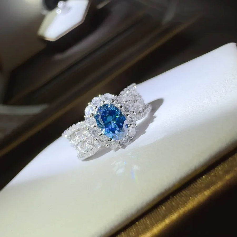 Silver ring with oval blue moissanite and halo of zircon stones