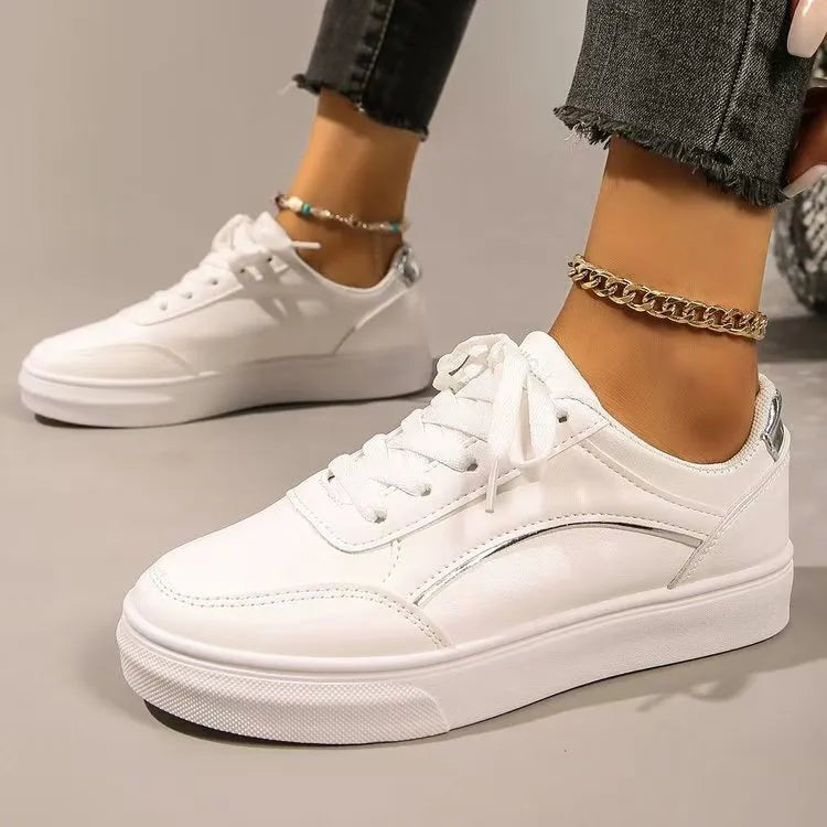 White sneakers with metallic trim and lace-up closure.