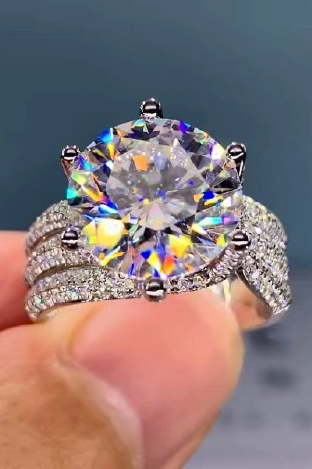 Silver pavé halo moissanite engagement ring with a large center stone.
