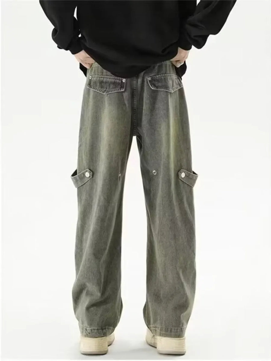 Vintage-inspired wide-leg cargo jeans in faded grey denim with button-flap side pockets.