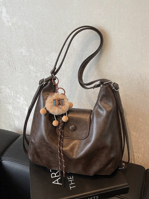 Vintage pu leather shoulder bag in olive brown with a distressed finish and cute lion charm.