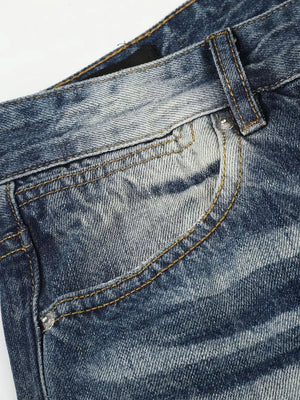 Blue distressed denim bootcut jeans with studded accents and contrast stitching.