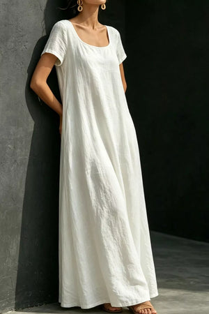 White polyester maxi dress with short sleeves, scoop neck, and pockets.