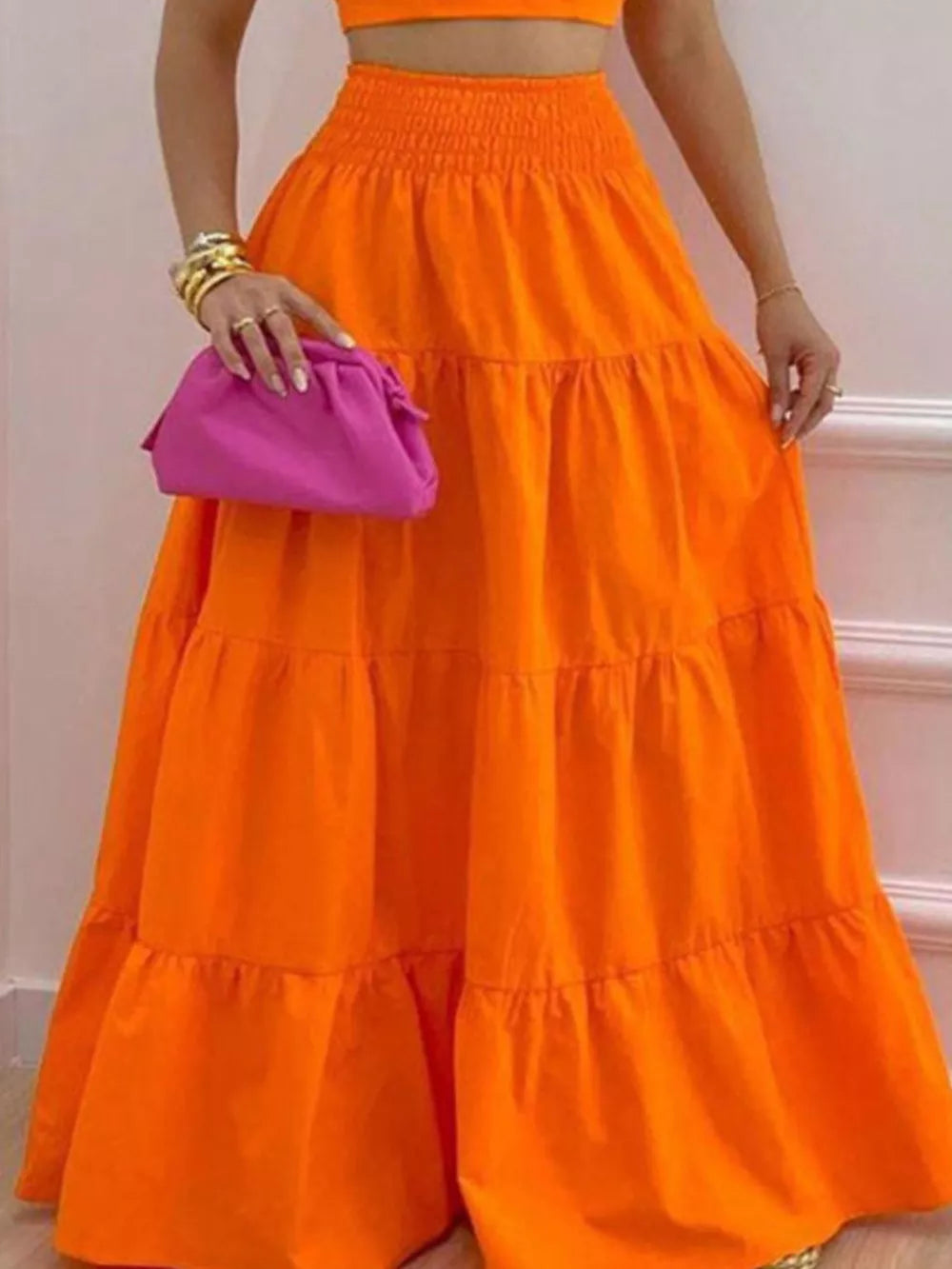 Orange ruffled tiered maxi skirt with smocked waist, paired with a crop top.