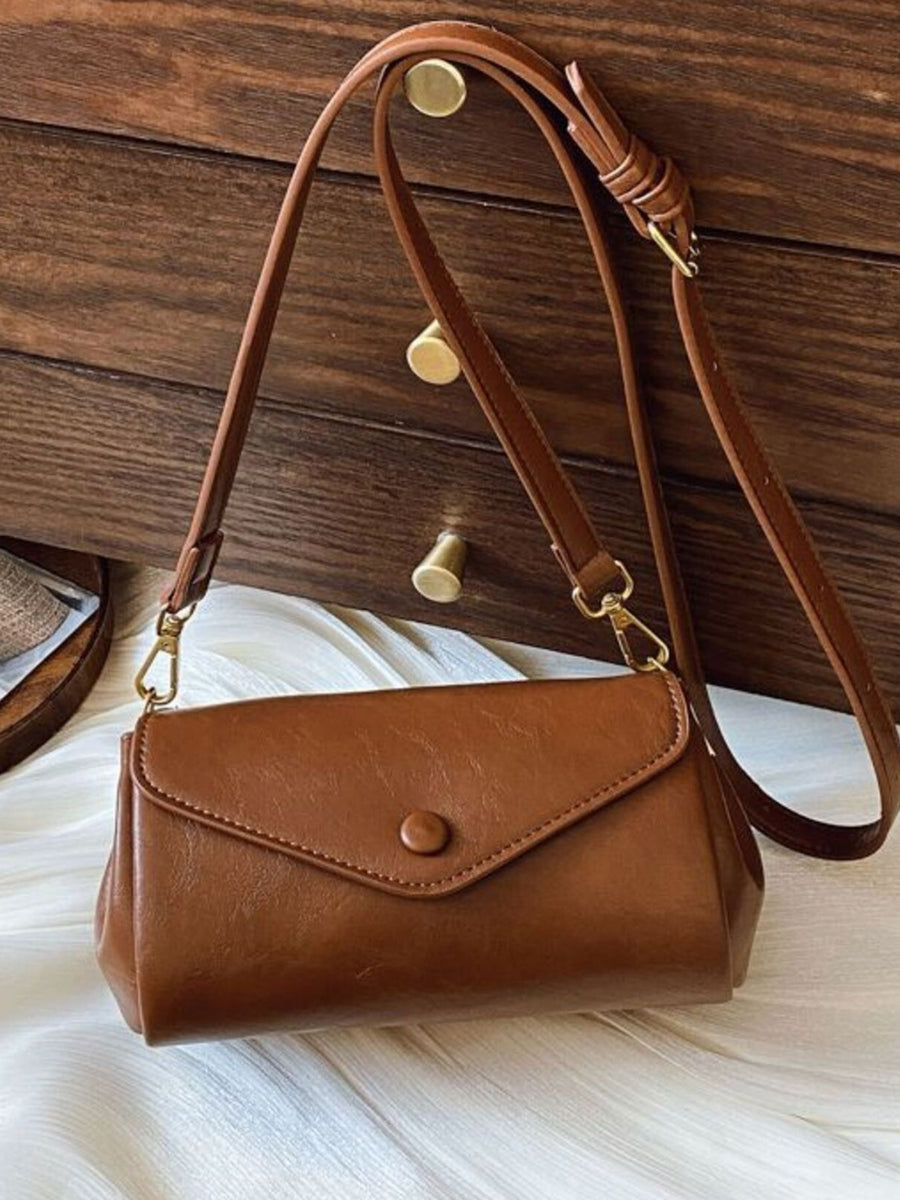 Mini pu leather flap crossbody bag in light brown with button closure and adjustable strap.