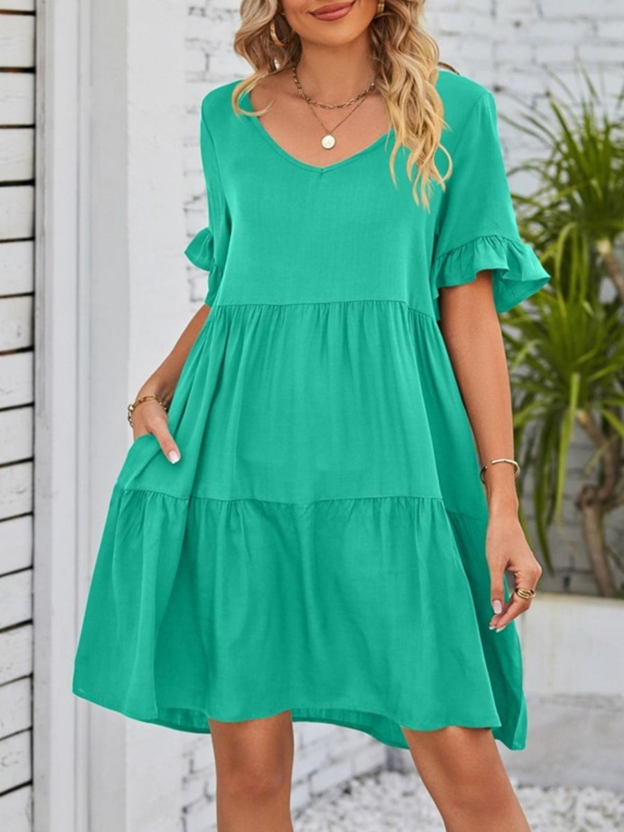 Emerald green tiered mini dress with ruffled sleeves and pockets