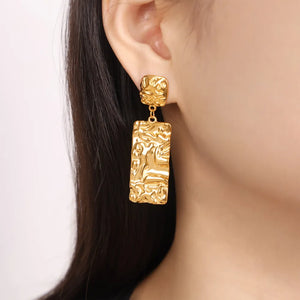 Gold crinkle rectangular drop earrings with textured surface detail.