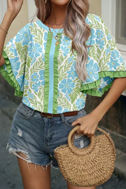 Floral ruffled half sleeve maternity blouse with blue flowers and green leaves.