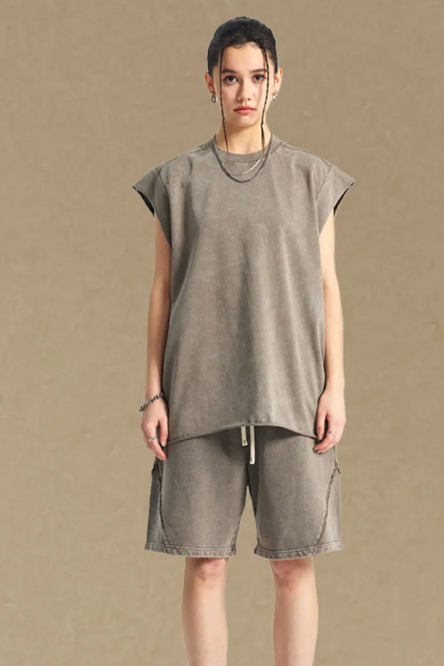 Raw edge muscle tank top in taupe with a crew neck and sleeveless cut.