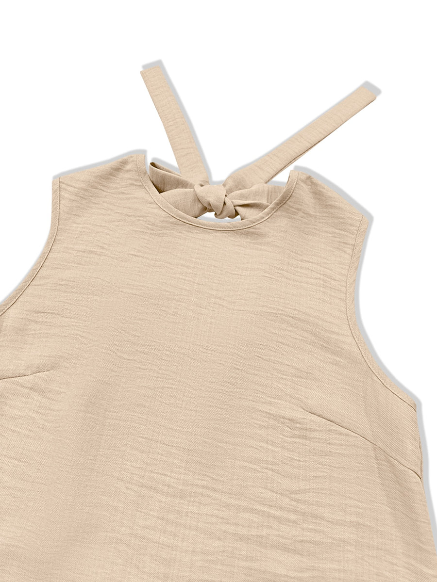 Backless mini dress in beige with tie-back detail and ruffled hem.