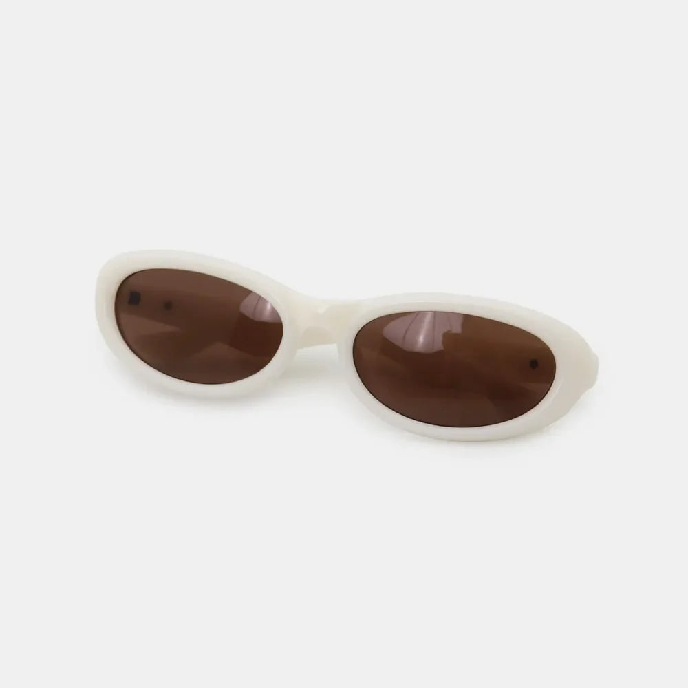 Ivory cat eye sunglasses with brown lenses and a chic, modern frame.