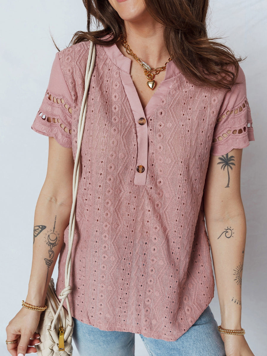 Pink eyelet embroidered short-sleeve blouse with button-down neckline and cutout details.