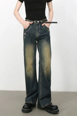 Faded wash dark bootcut jeans with button details and a belt.