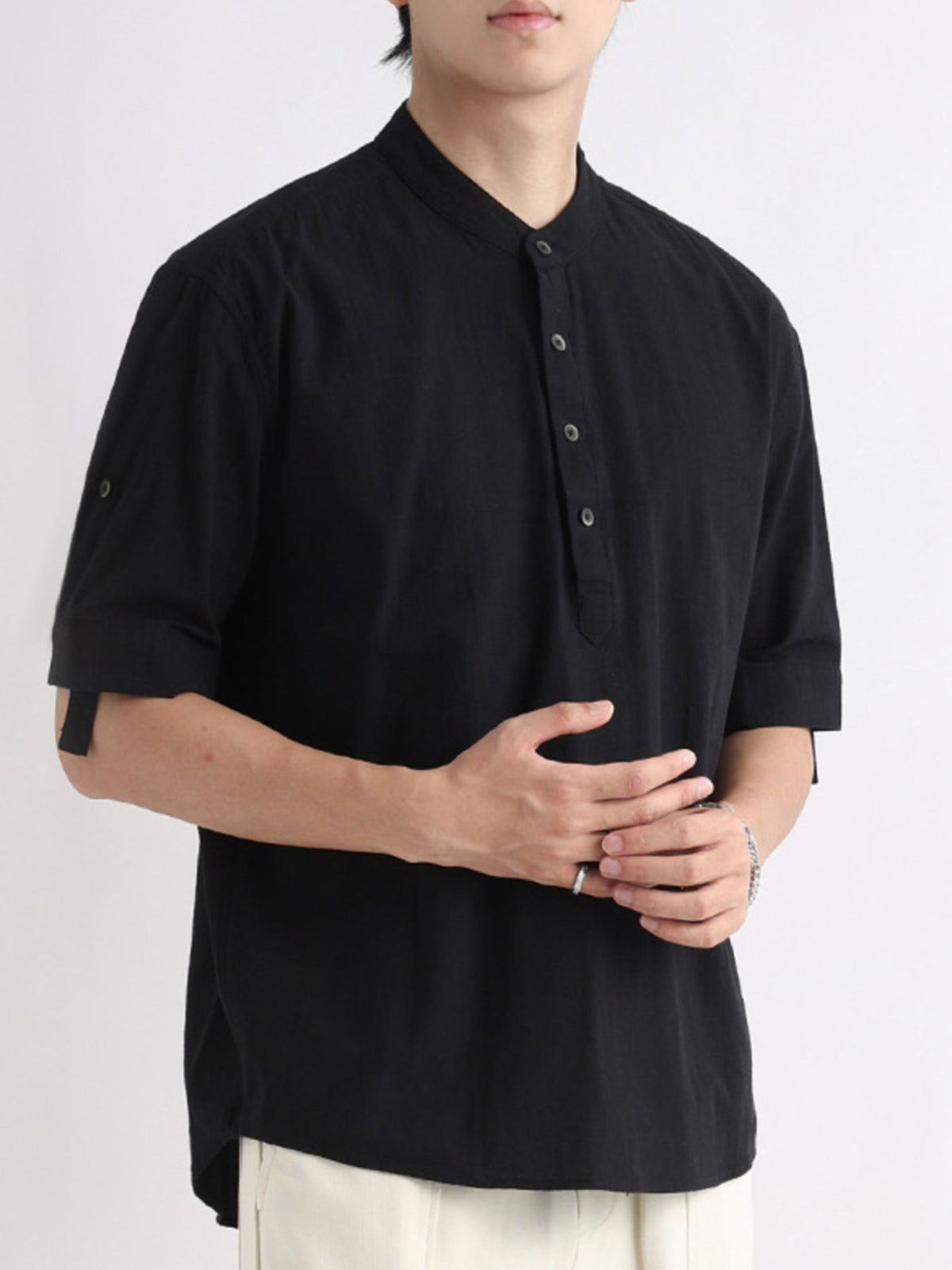 Black band collar button-down shirt with rolled sleeves.