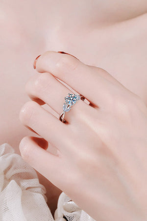 Silver moissanite ring with a central round cut stone and leaf-shaped accents.